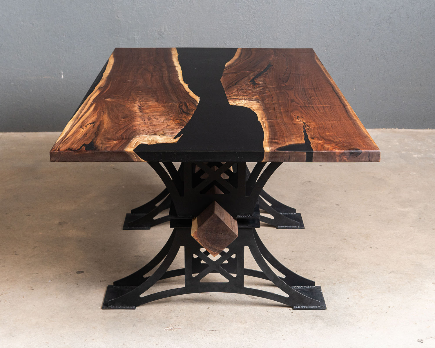 Walnut and Black epoxy river table with a large walnut beam going through the base