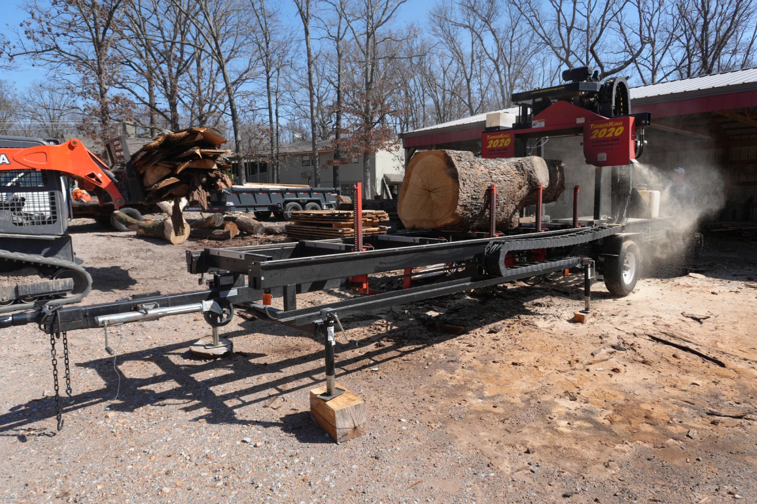 Picture of a timberking sawmill with logs and lumber in the background